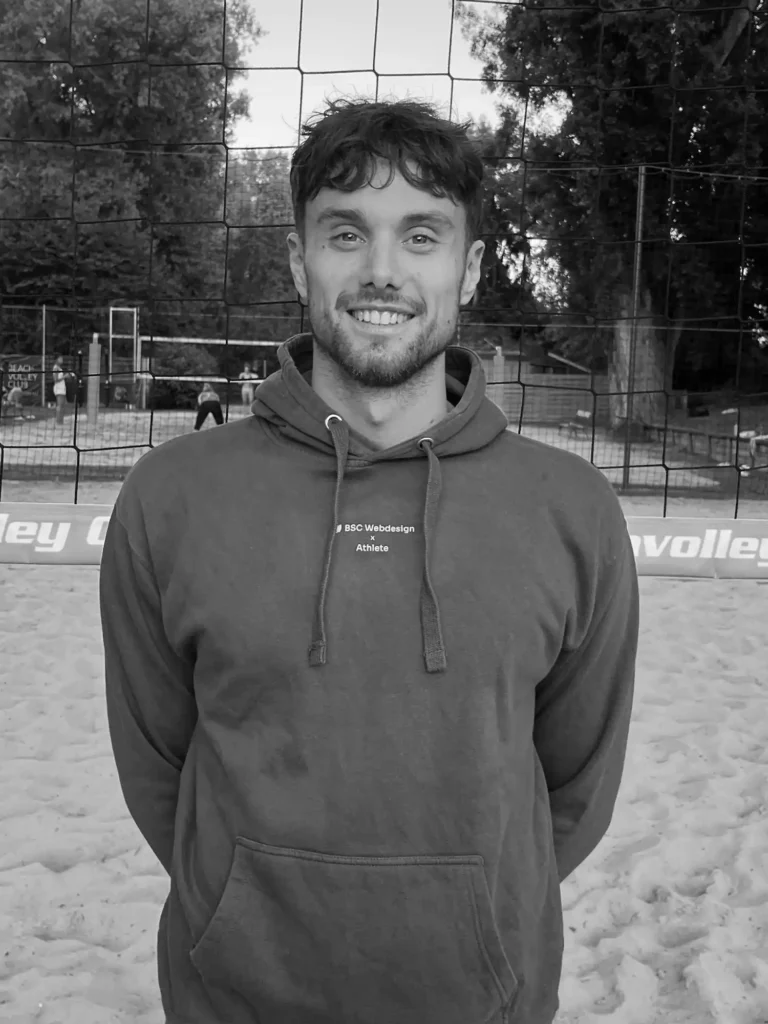 BSC Webdesign Athlete Michael Kessler im schwarz-weißen Portrait mit Hoodie am Beachvolleyballfeld.
